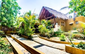 a courtyard of a house with trees and plants at Carpe Diem Casitas & Villas Mazunte in Mazunte