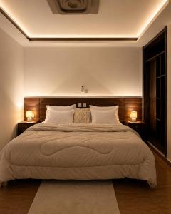 a bedroom with a large bed with two lamps at Suite BMB in Abidjan