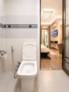 a bathroom with a toilet and a bedroom at Suite BMB in Abidjan
