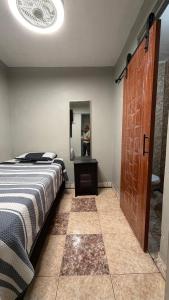 a bedroom with a bed and a mirror and a door at Hostal Arica 3 in Arica