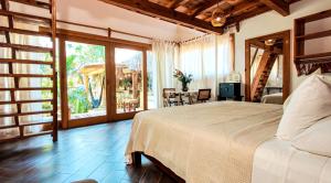 a bedroom with a large bed and a table and chairs at Carpe Diem Casitas & Villas Mazunte in Mazunte