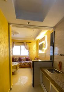 a bathroom with a sink and a couch in a room at منزل شامة in Moulay Yacoub