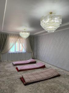 a room with three beds in it with chandeliers at Guest House Eltin in Bokonbayevo