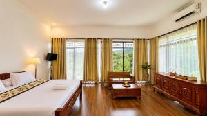 a bedroom with a large bed and a desk and window at Pondok Senaru Cottages in Senaru +16 photos