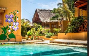 a swimming pool in front of a house with a mural at Carpe Diem Casitas & Villas Mazunte in Mazunte