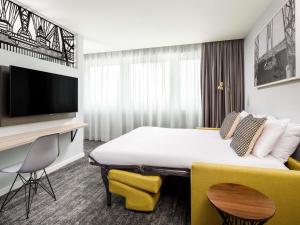 a hotel room with a bed and a flat screen tv at Mercure Newport in Newport