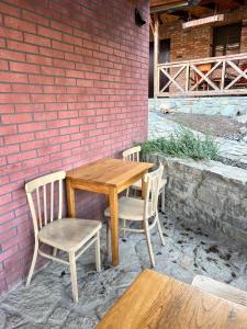 a wooden table and chairs next to a brick wall at Serce Kanyonu in Kamianets-Podilskyi