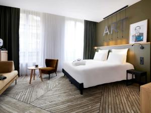a hotel room with a large bed and a chair at Mercure Grand Hôtel Metz Centre Cathédrale in Metz
