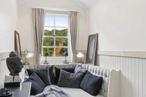 a living room with a couch and a window at Antara House by Coast Hosting in Matcham