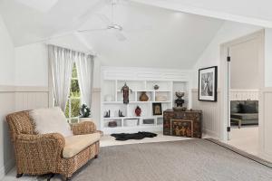 a living room with a chair and a table at Antara House by Coast Hosting in Matcham