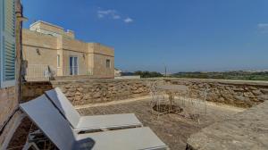 a patio with a table and chairs and a building at Wonderful 4BR Farmhouse with Private Pool in Rabat