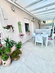 a patio with a table and chairs and potted plants at ΑVLI Sarti Studios & Apartments no 3 in Sarti