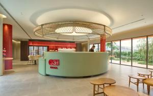 a lobby of a restaurant with tables and chairs at Go Hotel Nakhon Sawan in Ban Pak Nam Pho