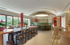 a dining room with tables and chairs in a restaurant at Go Hotel Nakhon Sawan in Ban Pak Nam Pho