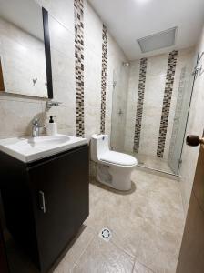 a bathroom with a toilet and a sink and a shower at Casa del Prado in Cali +5 photos