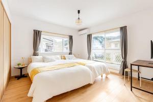 a white bedroom with a large bed and a window at Itoshima Private Villa 4LDK 4-Bedroom in Itoshima