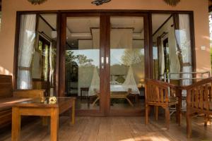 a living room with glass doors and a table at Papahan Bali in Sidemen