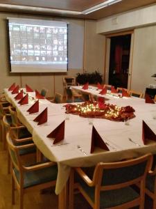 uma sala de conferências com uma longa mesa com guardanapos vermelhos em B&B Neulomotie em Orimattila