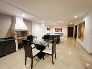 a dining room with a glass table and black chairs at Casa del Prado in Cali