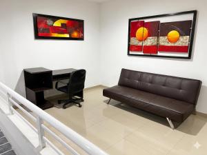 a living room with a leather couch and a desk at Casa del Prado in Cali