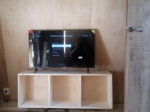 a television on a stand with a person taking a picture at Ada chalet in Mărăcineni
