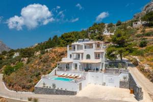 a large white house on a hill at Epsilon Apartments in Kalymnos