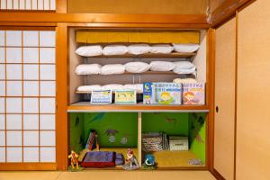 a shelf with towels and books in a room at 勝山恐竜博物館まで車で10分最大10名様ふとん屋の宿 悦 in Katsuyama