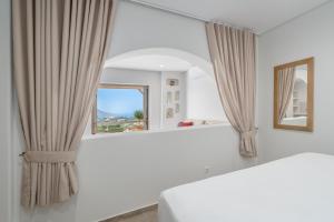 a bedroom with a bed and a mirror at Epsilon Apartments in Kalymnos +61 photos