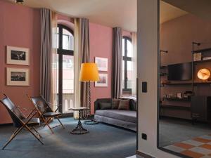 a living room with pink walls and a couch at 25hours Hotel Altes Hafenamt in Hamburg +26 photos