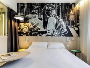 a bedroom with a white bed and a black and white photo at ibis Styles Limoges Centre in Limoges +125 photos