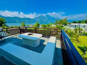 a view of the water from a balcony with a bench at Villa Danu Kintamani in Kintamani
