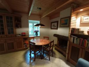 a kitchen with a table and chairs and a fireplace at Nice cottage in Brittany in Plouigneau
