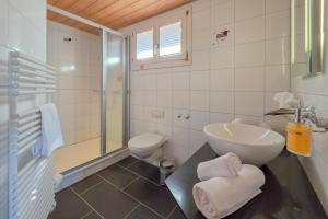 a bathroom with a sink and a toilet at Hotel Meielisalp in Leissigen +35 photos