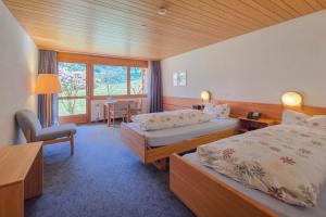 a hotel room with two beds and a table at Hotel Meielisalp in Leissigen