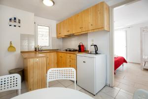 eine Küche mit Holzschränken und einem weißen Kühlschrank in der Unterkunft Elgrecosuits in Limenaria + 34 Fotos