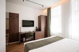 ein Schlafzimmer mit Bett, Schreibtisch und Fernseher in der Unterkunft Casa Versus Ohrid in Ohrid + 31 Fotos