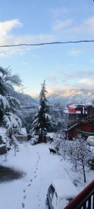 a snow covered yard with footprints in the snow at Adarsh homestay - 1BHK in Manāli +6 photos