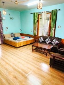 a living room with a couch and a table at Adarsh homestay - 1BHK in Manāli