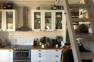 a kitchen with white cabinets and a stove at The Aspö Hideaway in Drottningskär