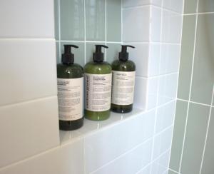 three bottles of soap sitting on a shelf in a bathroom at An190 Boutique Hotel in Bangkok +52 photos