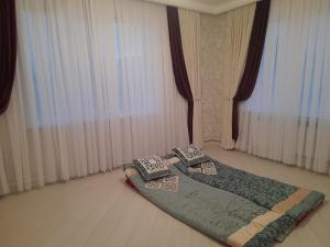 a bed in a room with two pillows on the floor at Guest House Maral in Bokonbayevo