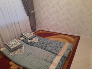 two beds with pillows on them in a room at Guest House Maral in Bokonbayevo +6 photos
