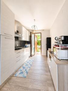 a kitchen with white cabinets and a tile floor at SweetHouse Pula in Porto Columbu - Perdʼe Sali