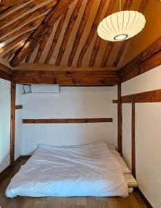 a bed in a room with a wooden ceiling at 경상북도 감성숙소 청화소담 in Yeongcheon