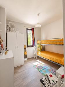 a room with two bunk beds and a kitchen at SweetHouse Pula in Porto Columbu - Perdʼe Sali