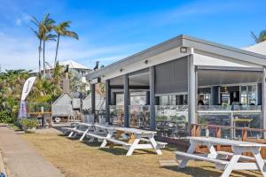 a row of picnic tables in front of a restaurant at Rosslyn Bay Resort Yeppoon in Yeppoon