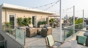 a balcony with chairs and tables on a building at Hotel Palace inn Agra in Tājganj
