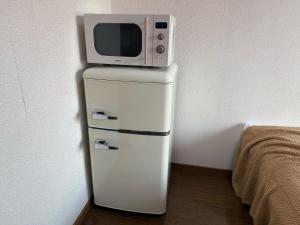 a microwave sitting on top of a refrigerator at 大濠ウエストビレッジ209 in Fukuoka