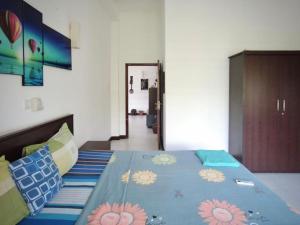 a bedroom with a bed with a blue comforter with flowers on it at White House 101 in Galle