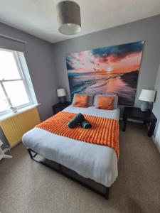 a bedroom with a large bed with an orange blanket at Brighton Central Home with free parking in Brighton & Hove